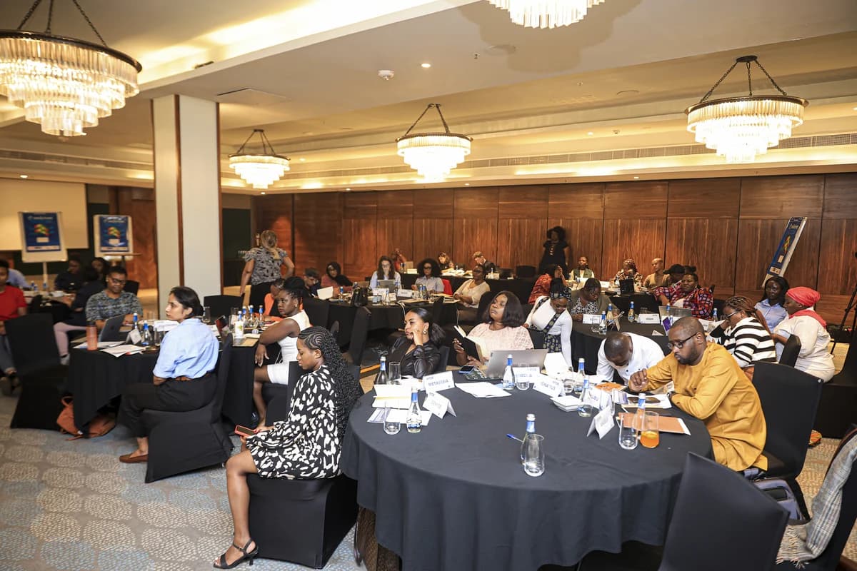 Conference attendees seated at round tables during a panel workshop